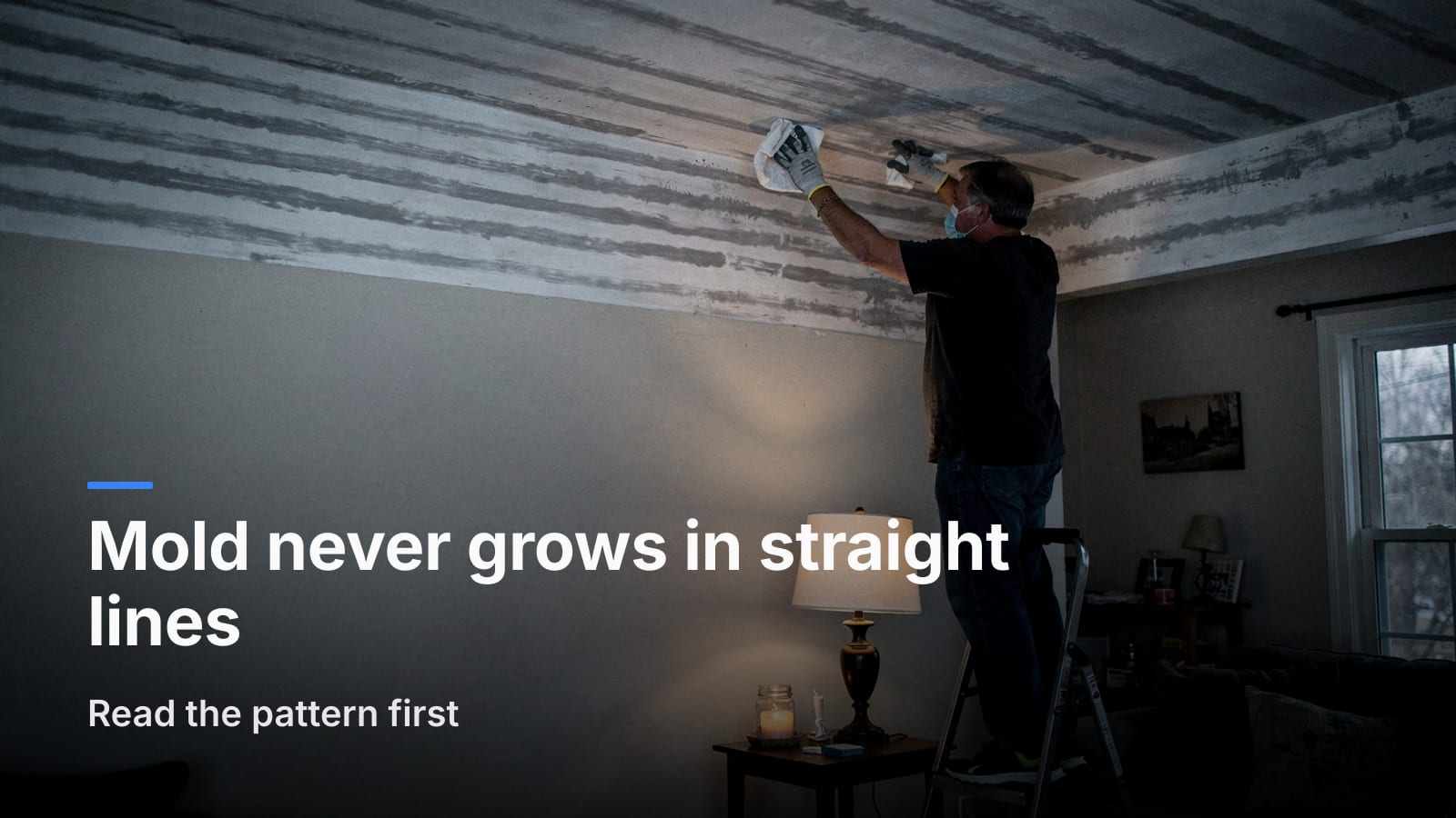 Person on a step stool wiping a white cloth across evenly spaced dark gray stripes on a white ceiling.